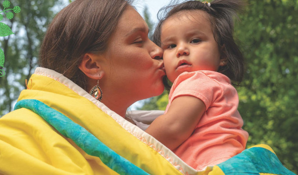 Woman Wrapped in Blanket Kisses Toddler in Her Arms